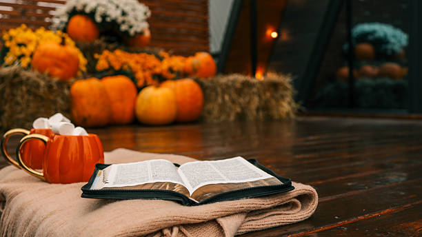 istock Autumn scene with pumpkins, mugs, marshmallows, and an open book 2244488358