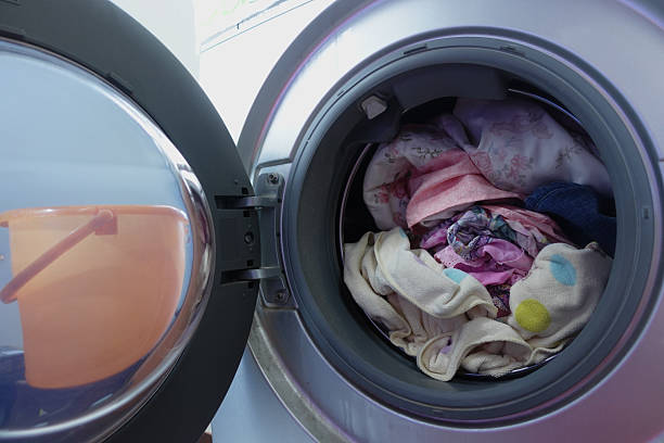 istock Washing machine loaded with clothes ready for a cycle 2244489979