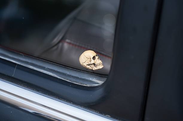 A close-up of a custom car interior detail, featuring a small skull figurine used as a door lock knob.