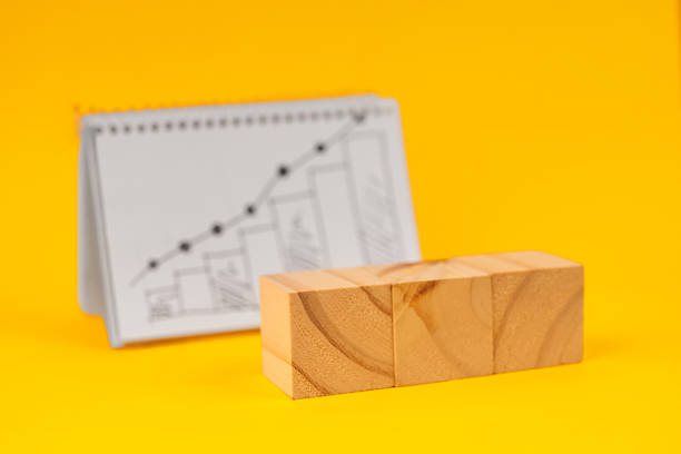 istock Three wooden blocks placed before a rising business chart symbolizing strategy building, planning steps, and scalable growth. 2244492868