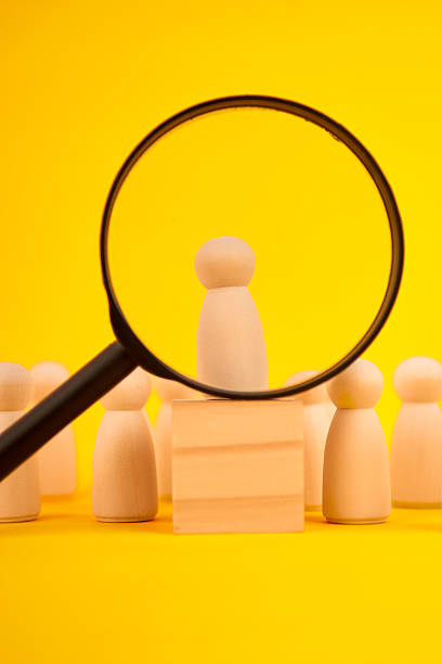 istock Magnifying glass highlighting a standout candidate among wooden figures, representing recruitment, talent selection and the search for the best fit. 2244493039