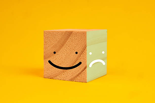 Dual face cube showing happy and sad expressions, conveying customer sentiment, service evaluation and the balance between positive and negative feedback, capturing mixed experiences to guide improvement.