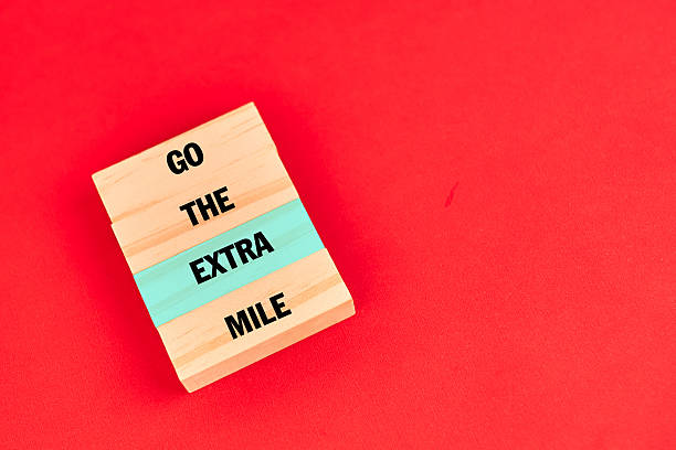 istock Go the Extra Mile message on tiles with a highlighted bar to emphasize priority and excellence, encouraging commitment to exceed expectations. 2244493146