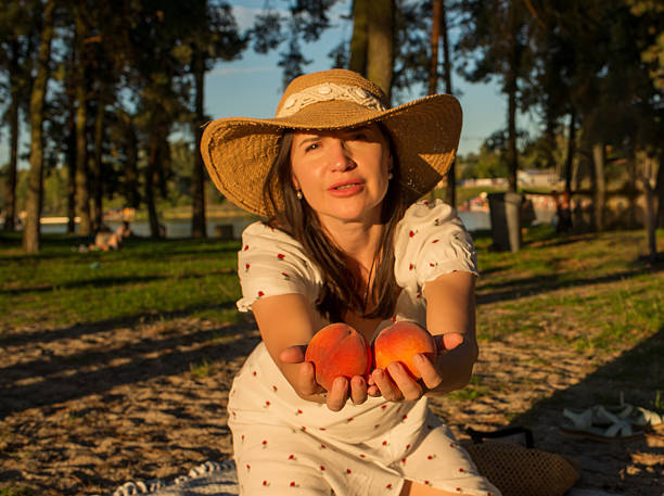 Portrait of beautiful naked young african girl with a light natural make-up and perfect skin with pomegranate in her hand, posing indoors in red pomegranate garden or greenhouse.