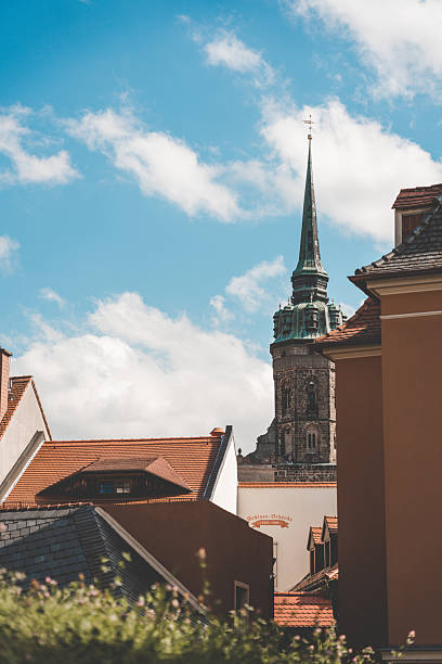 View across tiled rooftops to a historic church spire in Bautzen, Germany.