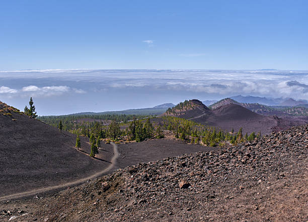 istock Volcanic trail with pines and clouds 2244512018