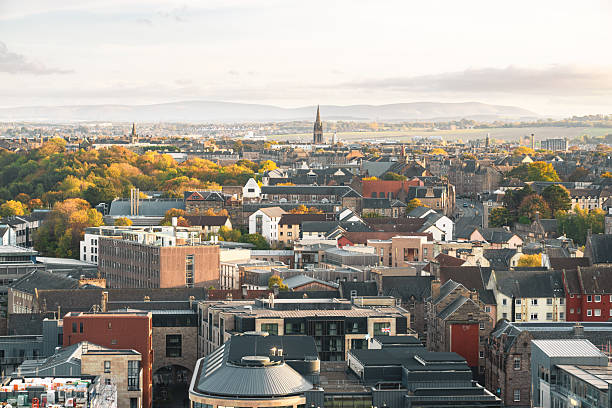 Panoramic view of edinburgh cityscape showcasing various buildings and autumn foliage