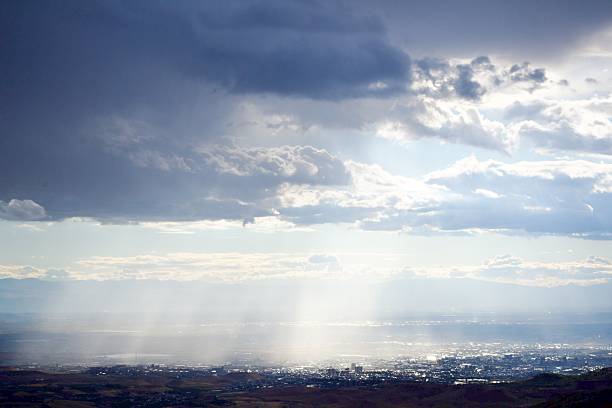 istock Sunbeams and god rays over a city valley as storm clouds break 2244513175