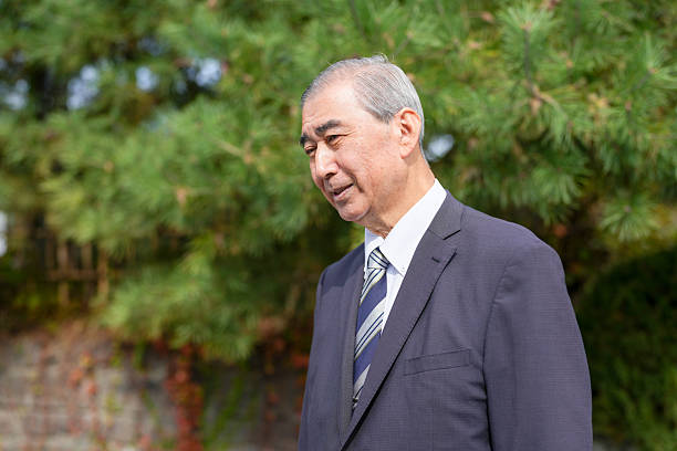 istock A man in a suit and tie stands in front of a tree 2244527460