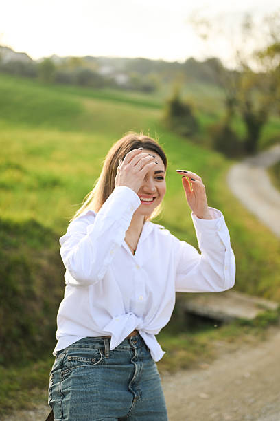 Young woman laughing, feeling happiness and freedom while standing in countryside