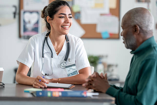 istock Latina Nurse Practitioner Smiles While Consulting With Elder Black Patient In Clinic setting 2244535483