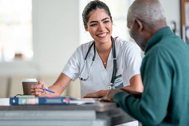 istock Latina Nurse Smiling At Patient While Discussing Paperwork At Front Desk During Care Visit 2244535504