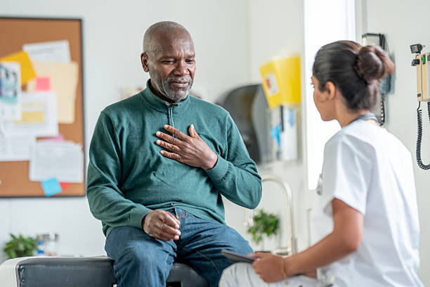 istock Older Black Man Seated On Exam Table Speaking With Nurse In Clinic Setting, Expressing Concern And Gratitude 2244535599