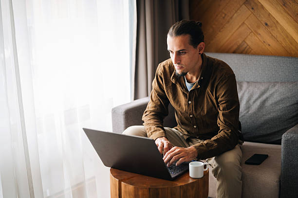 istock Young man in a comfort room working on his laptop. 2244535610