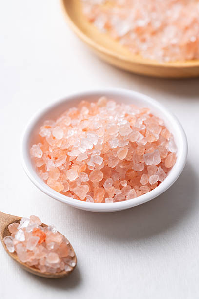 istock Himalayan pink salt in bowl and spoon on white background 2244547452