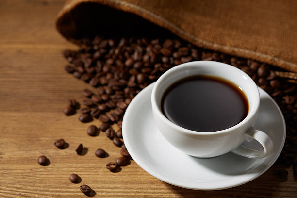 istock Cup of coffee with grains on wooden background 2244547835