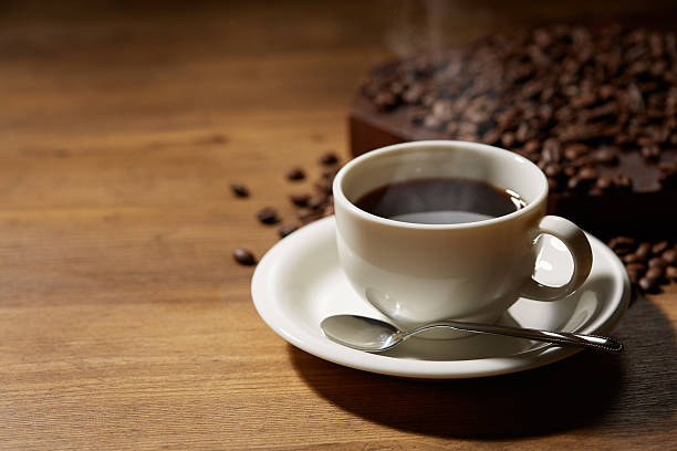 istock Cup of coffee with grains on wooden background 2244547870