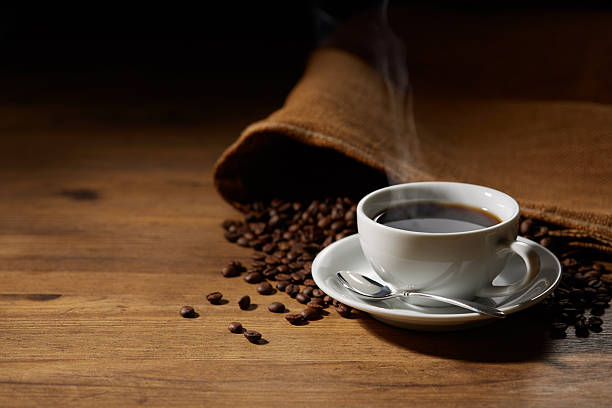 istock Cup of coffee with grains on wooden background 2244547921