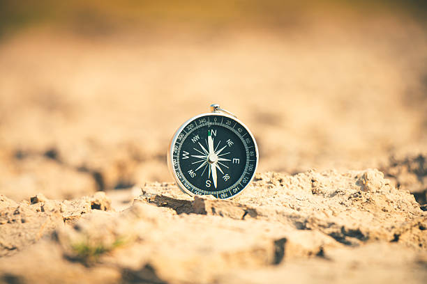 istock The dry, barren land stretches endlessly as a compass points toward hope and solutions for the drought crisis. 2244550943