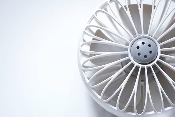 Close-up of mini electric fan with handle isolated on white background