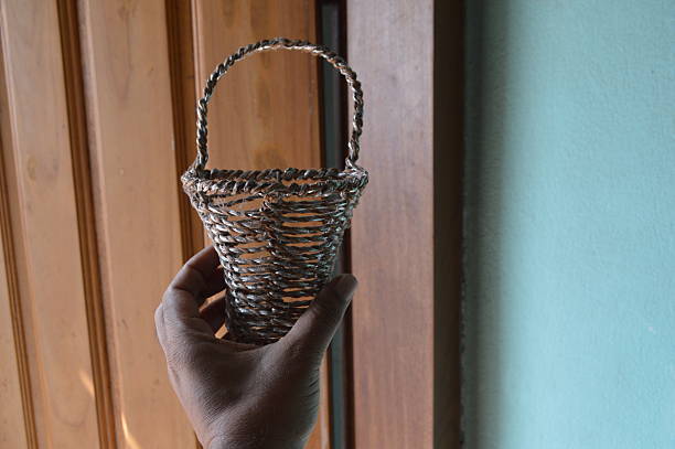 Man holding small decorated basket by hand in the inside room