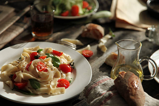 A plate of pasta with fresh tomatoes and greens, looking very appetizing and delicious.