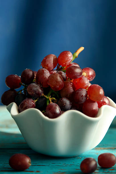 ripe grapes in a glass bowl on a yellow background in the rays of the morning sun