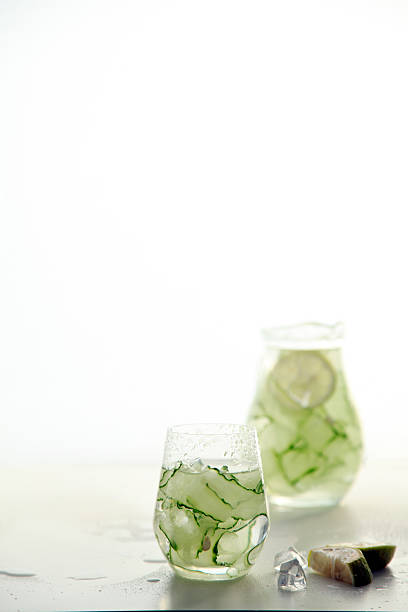 Refreshing cucumber lime drink in glasses on light background