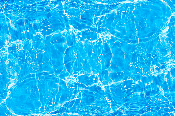 istock Blue water with ripples on the surface. Defocus blurred transparent blue colored clear calm water surface texture with splashes and bubbles. Water waves with shining pattern texture background. 2244563644