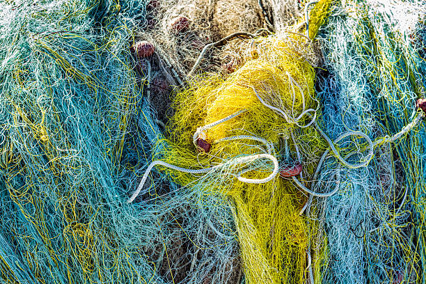 Thessaloniki, Greece – 24 October 2025: Close-up of colorful tangled fishing nets with yellow and blue ropes and small red floats. The image highlights the texture and complexity of traditional fishing gear, symbolizing craftsmanship, work, and connection to the sea.
