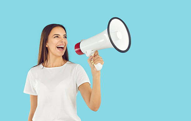 istock Smiling young woman shouting into megaphone making recommendation 2244567734