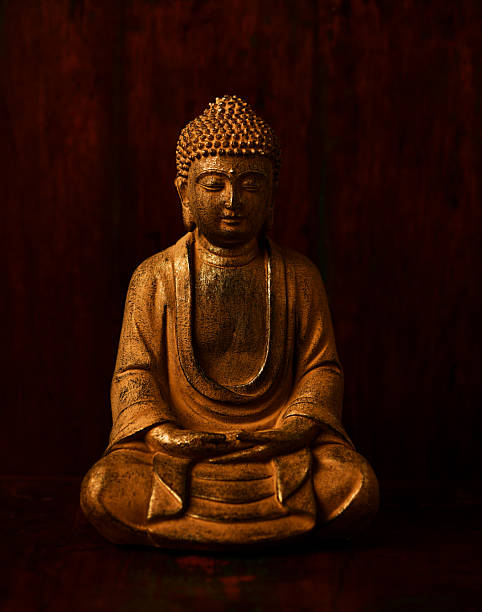 Meditating Buddha Statue on dark background. Soft focus. Close up. Copy space.