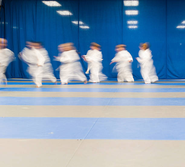 istock Children in karate uniforms running in dojo 2244568015
