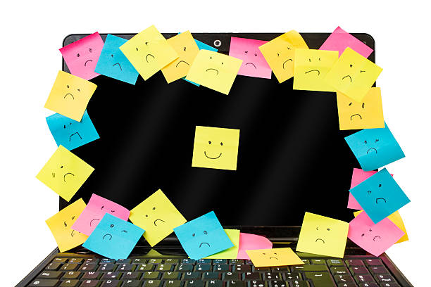 Many colorful sticker posts with sad and smile expressions on a black laptop screen isolated on white background,  happiness metaphor