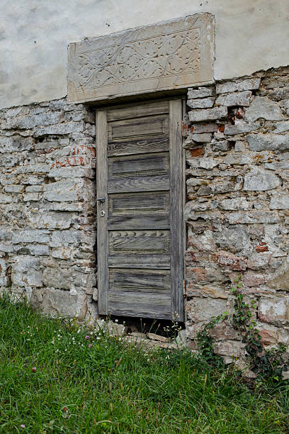 istock Wooden old door with stone masonry, with green grass 2244568984