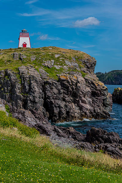Admirals Point Lighthouse above the cliffs on the coastline near Trinity, Newfoundland