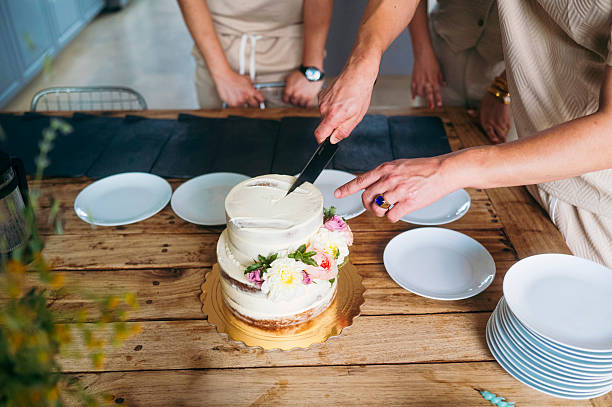 istock People cutting white cake with flowers on table 2244569199