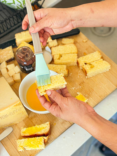 istock Person brushing butter on bread slices in kitchen. 2244569212