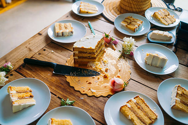 istock Half-eaten layered cake on wooden table with plates. 2244569234
