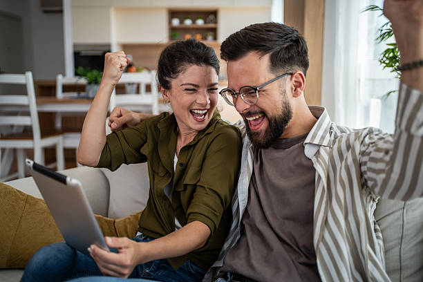 istock Excited couple celebrating success with a digital tablet 2244570072