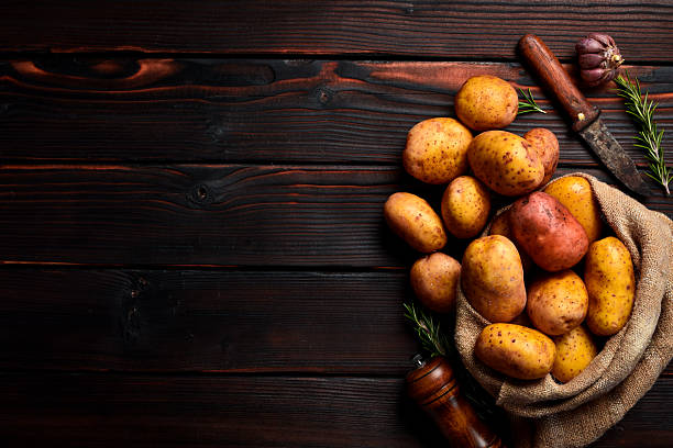 istock Fresh potatoes in a canvas bag, on a wooden textured background. 2244570560