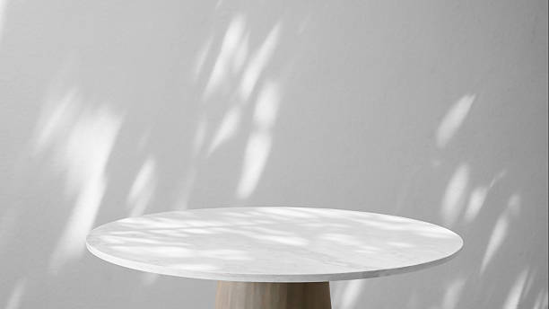istock Round marble table top with tree leaves shadow drop on white wall background for mockup product display 2244574902