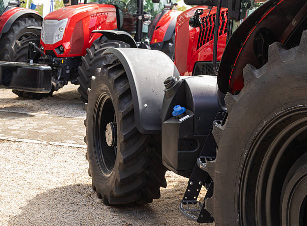 istock New agricultural tractors displayed in a row. 2244577513
