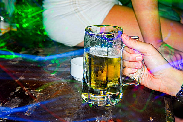 istock Hand holding a glass of beer on the table 2244580856