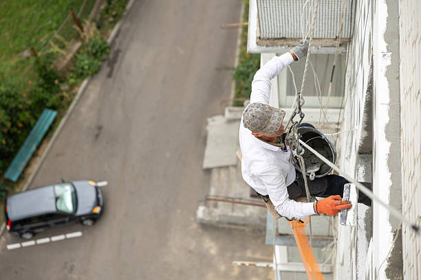 istock Construction worker seals the joints between polystyrene panels with adhesive at the height of the ninth floor of the building. 2244585728