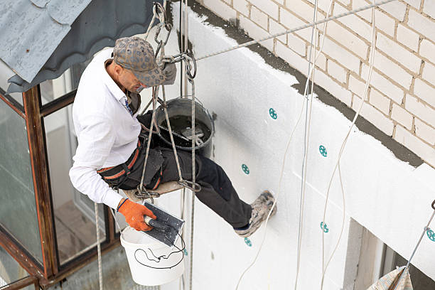 istock Construction worker insulates the facade of a building on the ninth floor. 2244585784