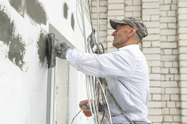 istock Construction worker seals the joints between polystyrene panels with adhesive at the height of the ninth floor of the building. 2244585825