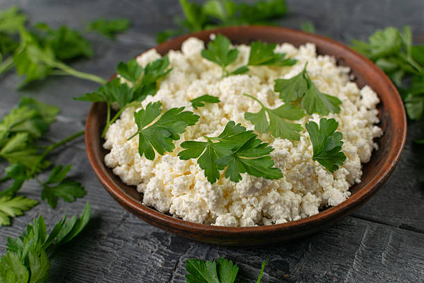 istock Fresh Cottage Cheese in Rustic Bowl with Parsley on Dark Wooden Table 2244586033