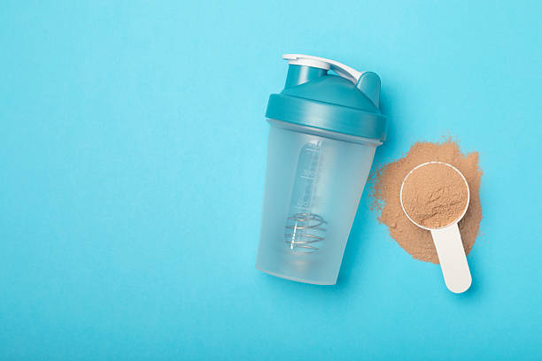 istock Protein shake with protein powder on a colored background. The powder is mixed with water or milk. A dietary supplement for a balanced diet. Whey protein. Fitness and gym diet nutrition. 2244586801