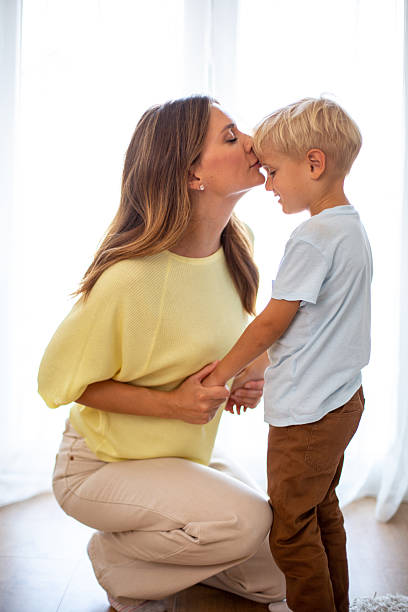istock Mother kissing son's forehead, bonding momentindoors 2244589194